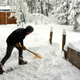 man shoveling snow in backyard